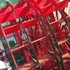 The image shows the red paddles of a paddle wheel churning through the green water, likely from a riverboat.