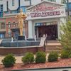 The image shows the entrance of the Hollywood Wax Museum, adorned with large lettering, a central sculpture, and an image of King Kong, as viewed from a car window.