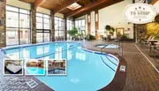 The image shows an inviting indoor pool area with wooden beams, stone accents, and lounge chairs, featuring text about amenities like free breakfast, an indoor pool, and an outdoor pool.