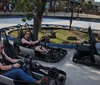 A group of people are enjoying a go-kart ride on a sunny day at an outdoor track.