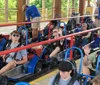 A group of people are enjoying a go-kart ride on a sunny day at an outdoor track.