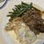 The image depicts a plate containing a serving of green beans, mashed potatoes, and shredded meat, possibly roasted or braised, with some gravy or sauce.