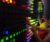 A family is engaged in an interactive exhibit with adults and children focused on an activity at a table