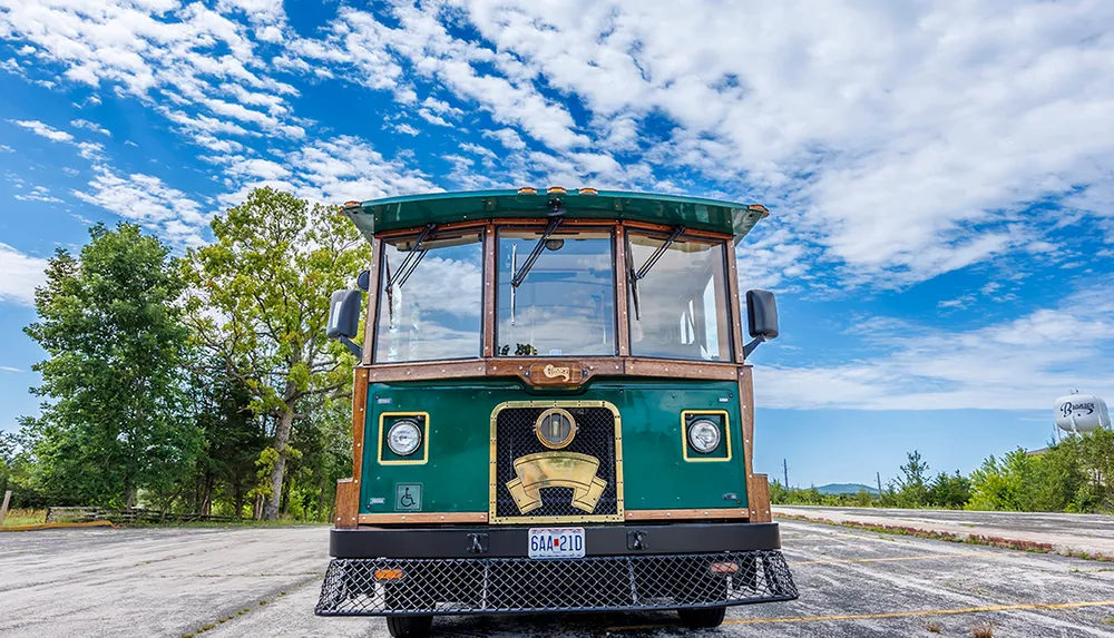 A trolley bus is parked under a blue sky dotted with white clouds