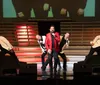 A group of performers is singing passionately on a dramatically lit stage accompanied by red lighting and stage smoke