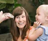 A child is looking closely with wide eyes at a butterfly perched on their nose