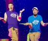 Two performers are on stage with surprised expressions holding spinning plates on sticks against a starry background