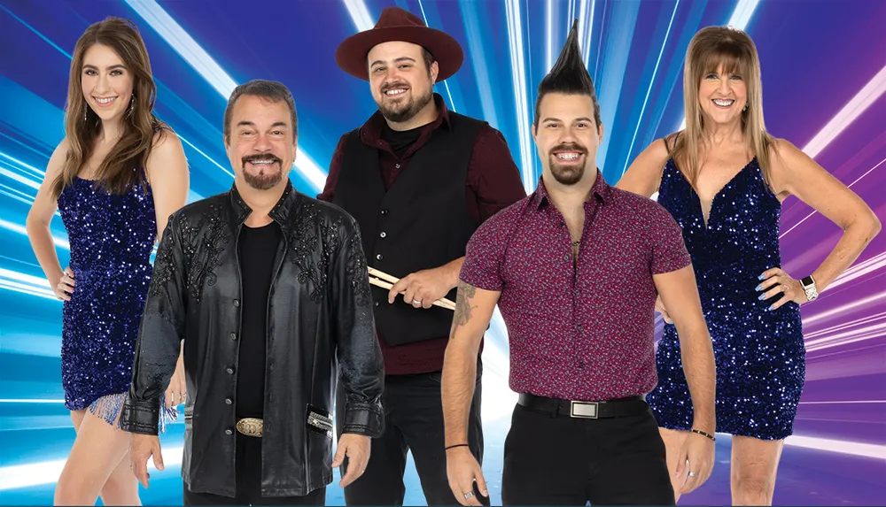 Five people pose with cheerful expressions against a vibrant blue background likely for a promotional or entertainment event