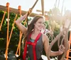 A group of people is enjoying a high ropes adventure course on a sunny day